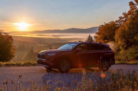 Toyota driving up Toll Road at Sunrise in Stowe